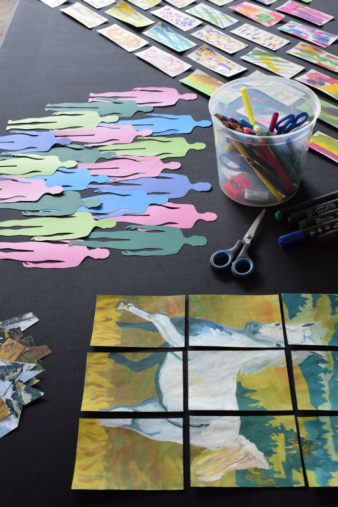 Siluetas de papel de colores, tarjetas pintadas y un caballo pintado en piezas sobre una mesa