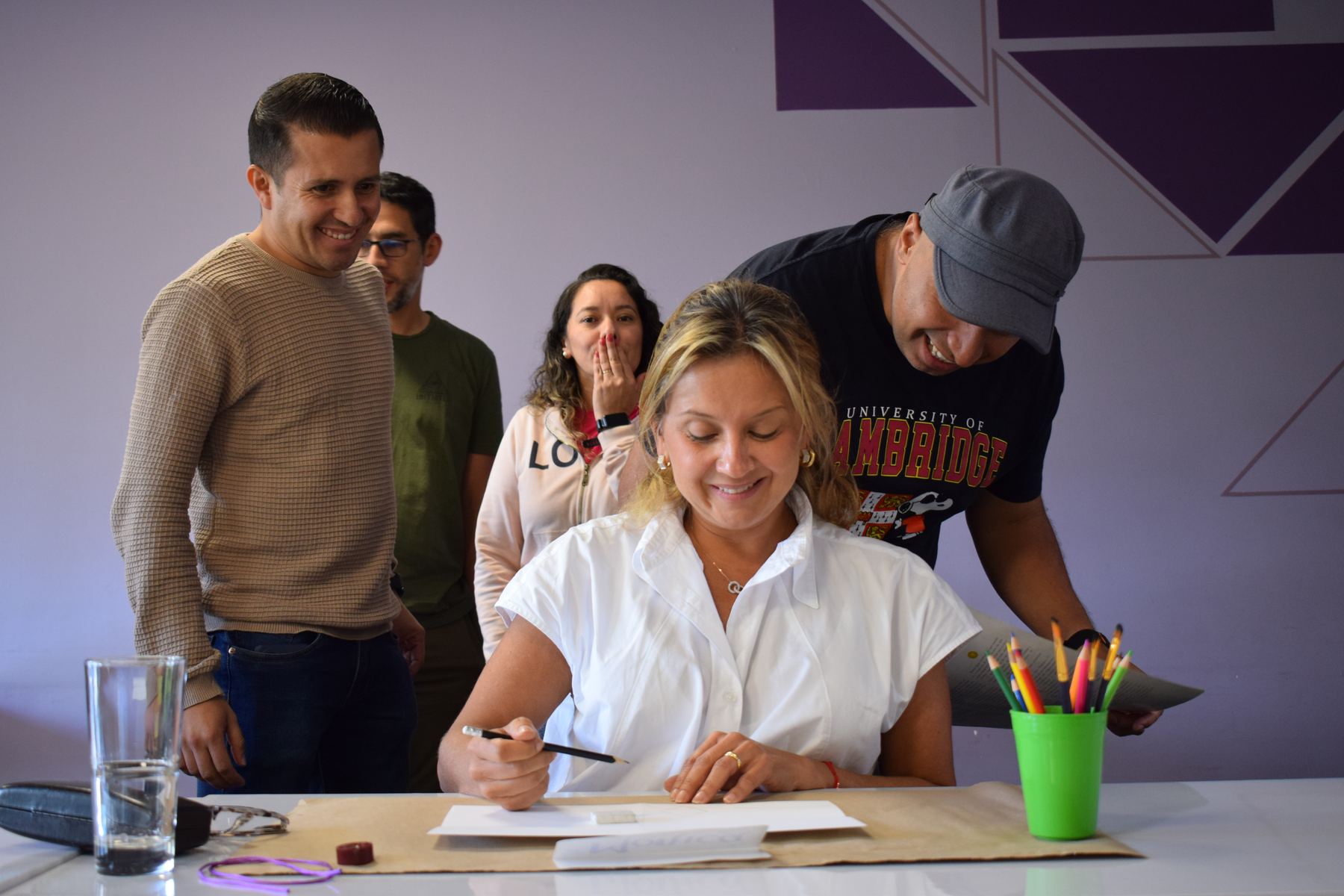 Un equipo se ríe mientras una participante dibuja durante una sesión de Simoné